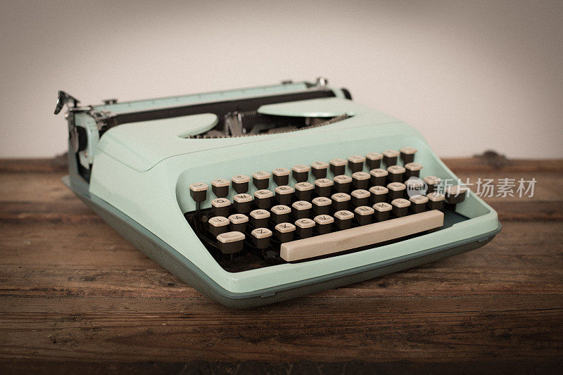 老式手动打字机在木头树干，浅蓝绿色