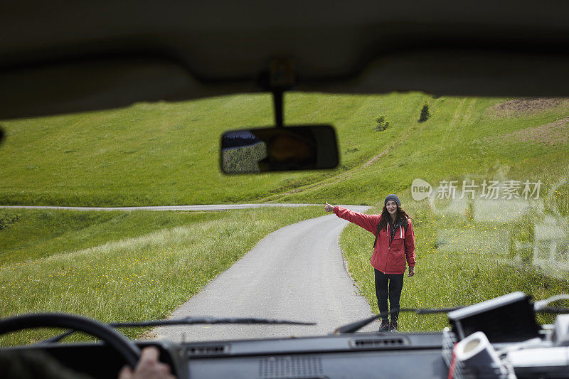女人搭便车旅行。多山的地形。司机的观点