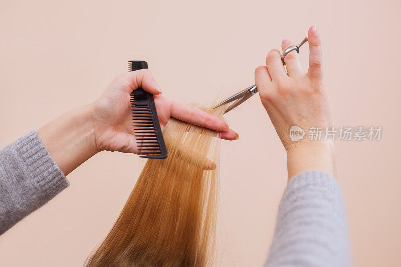 理发师用剪刀为一个年轻的女孩理发