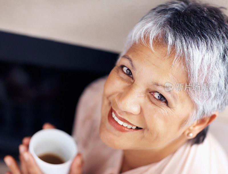 一个快乐的老女人拿着一杯咖啡的特写