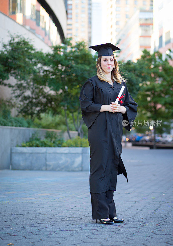 女大学生戴毕业帽，穿着毕业袍，手持毕业证书