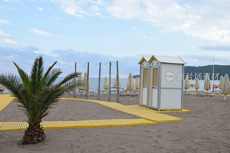 海滩设备:木板路、淋浴器、移动厕所、雨伞和躺椅