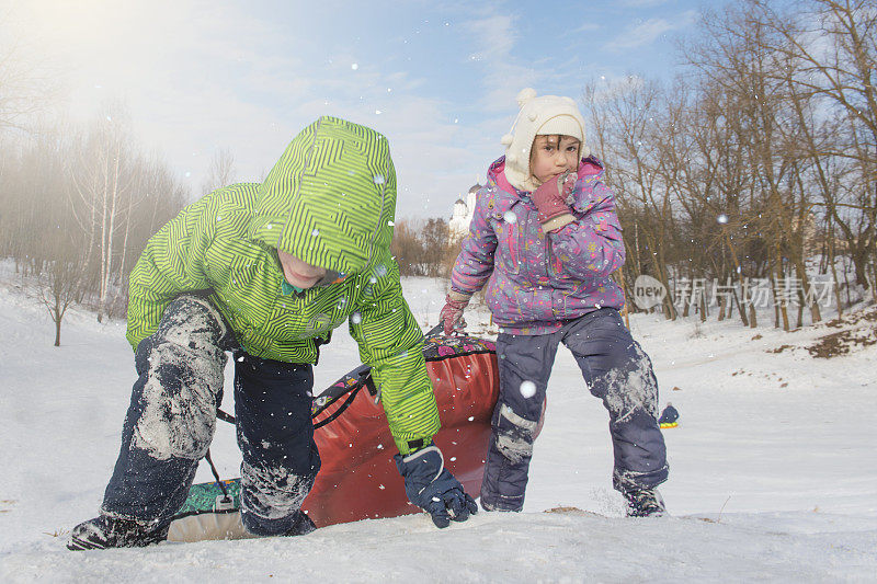 孩子们在山上玩雪橇。