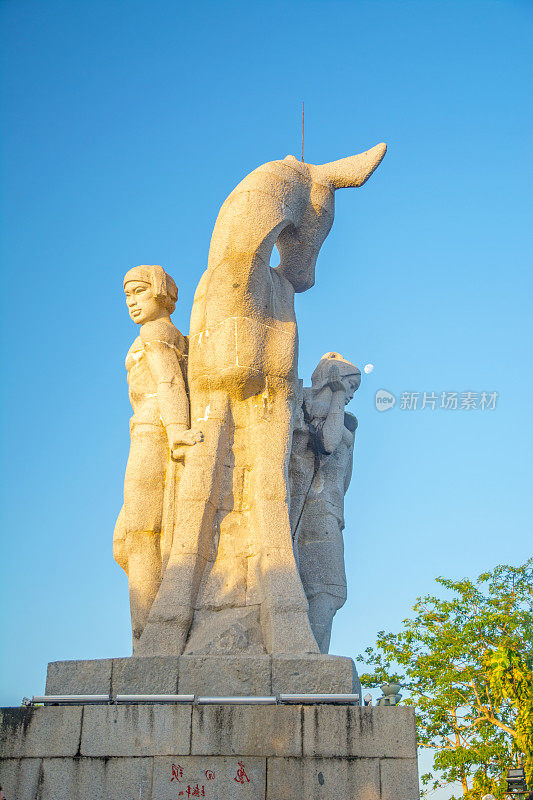 在中国的一座高山公园里，哈特转过头来。一个女孩和男朋友的高雕像。一个国家的传说。