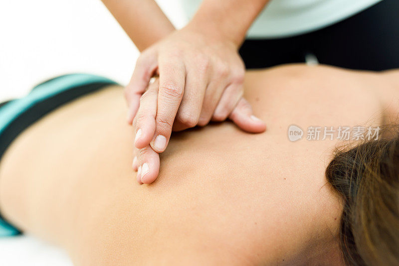 一名年轻女子在水疗中心接受背部按摩。
