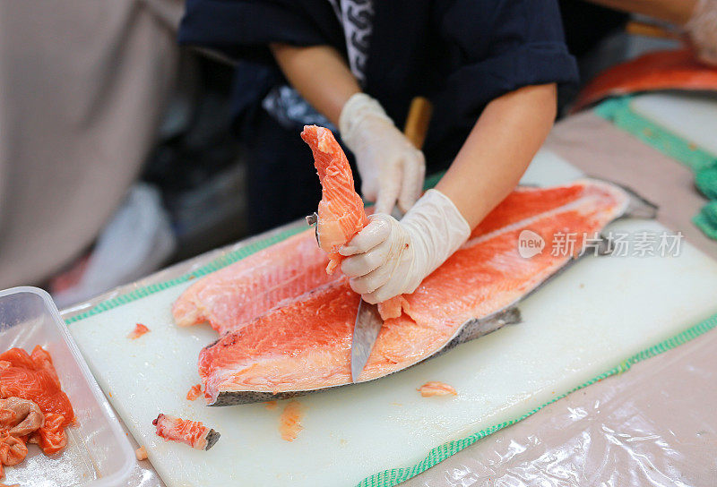 厨师在砧板上准备新鲜的鲑鱼。