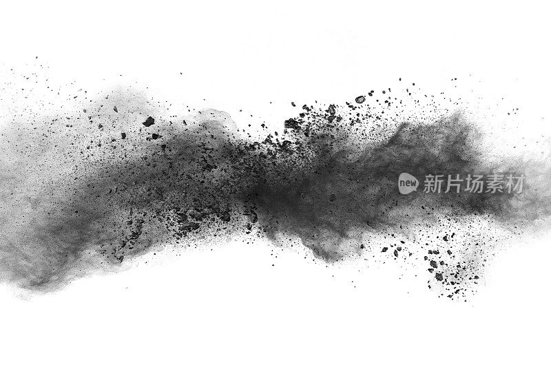 黑火药爆炸。木炭的颗粒飞溅在白色的背景上。特写的黑色尘埃颗粒飞溅孤立的背景。