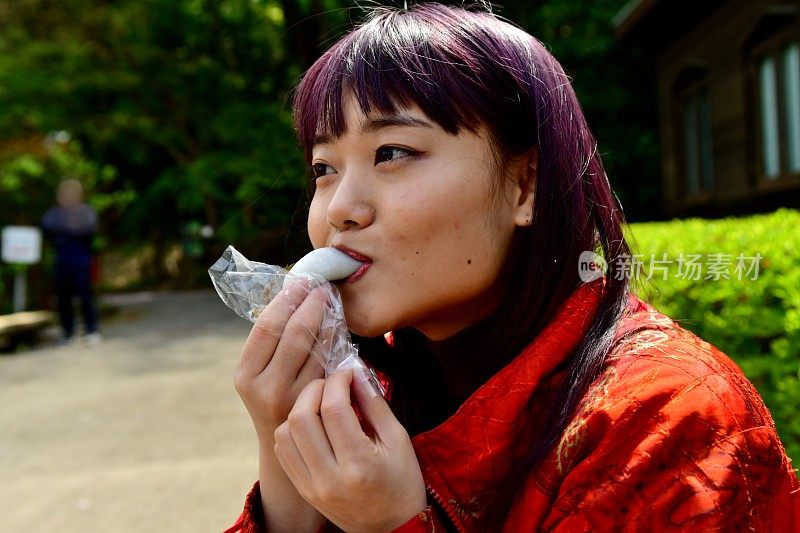 一名年轻的日本女子在花见之后享用樱花蛋糕