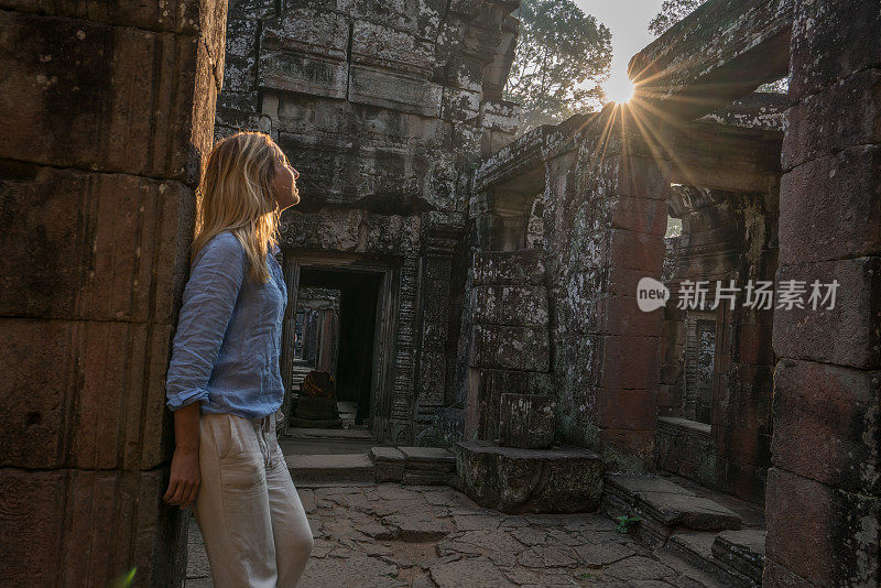 女游客漫游在古老的寺庙日落享受发现和旅游在亚洲，柬埔寨吴哥窟