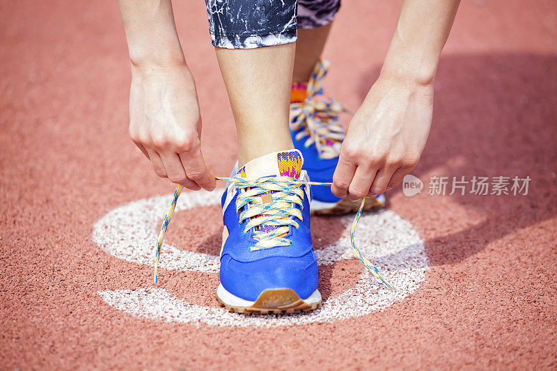 年轻女子跑步系鞋带