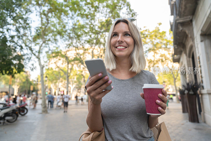 购物的女人发短信，在户外喝咖啡