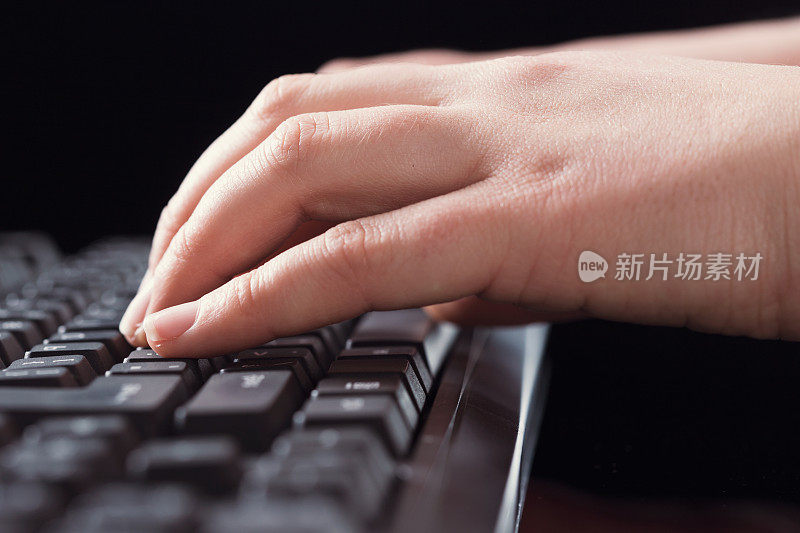 特写女性的手在电脑键盘上打字