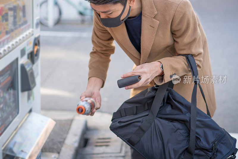 年轻的日本人和亚洲朋友从日本的自动售货机购买饮料