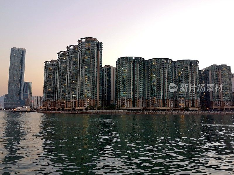 香港九龙日落时维多利亚港的住宅大厦