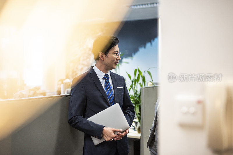 一个中国商人在办公室和他的同事聊天