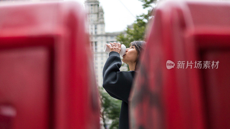 年轻女子喝着咖啡走在曼哈顿的大街上