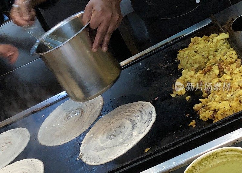 酒店餐厅厨师在厨房热板上制作美味的印度薄饼