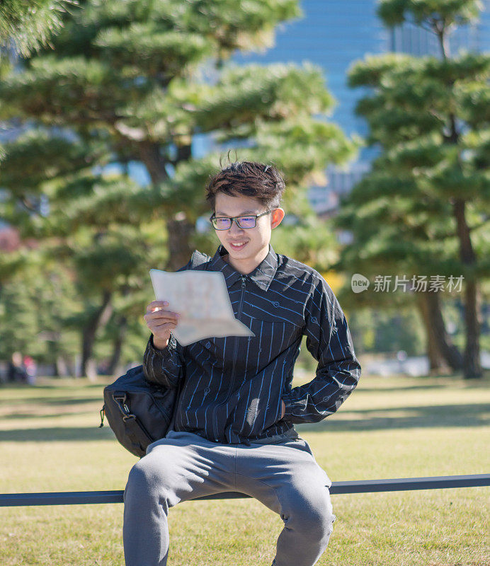 年轻的亚洲人日本人寻找旅游地点使用手机和花时间在亚洲旅行