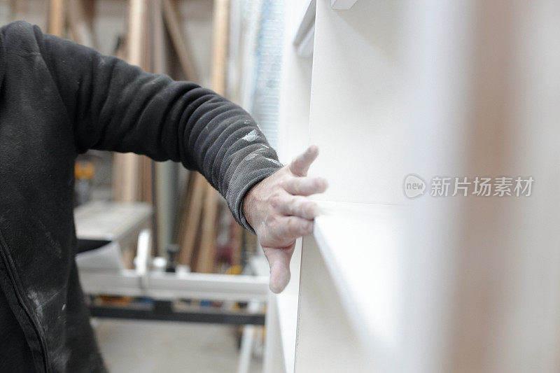 木匠打磨新制作的油漆橱柜