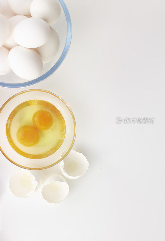 鸡蛋，打蛋器，面粉和擀面杖在白色的背景