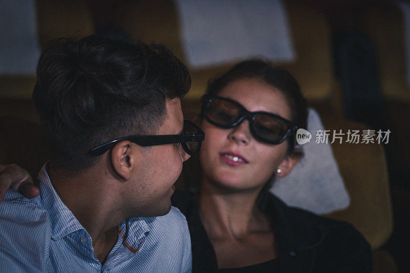 一对年轻夫妇在电影院幸福地看电影