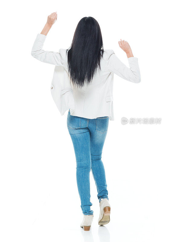 拉丁美洲和西班牙裔女性穿着牛仔裤在白色背景前跳