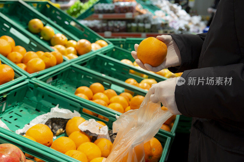 男性戴着防护手套在超市购物