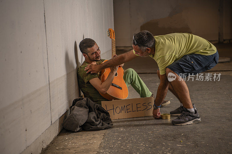 绝望的男人和吉他是接受钱从一个人在城市地下