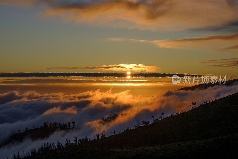 日落时分，马德拉岛Raba?al附近群山上空的云朵