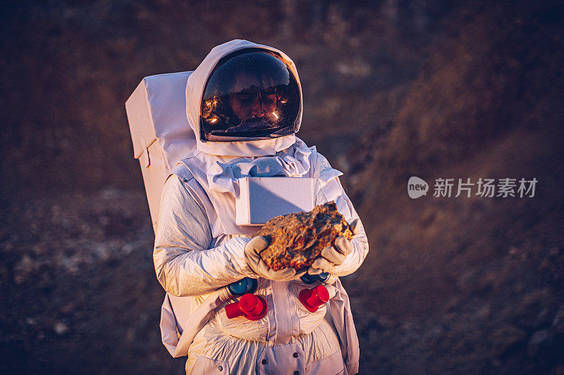 宇航员在火星上拿着一块石头