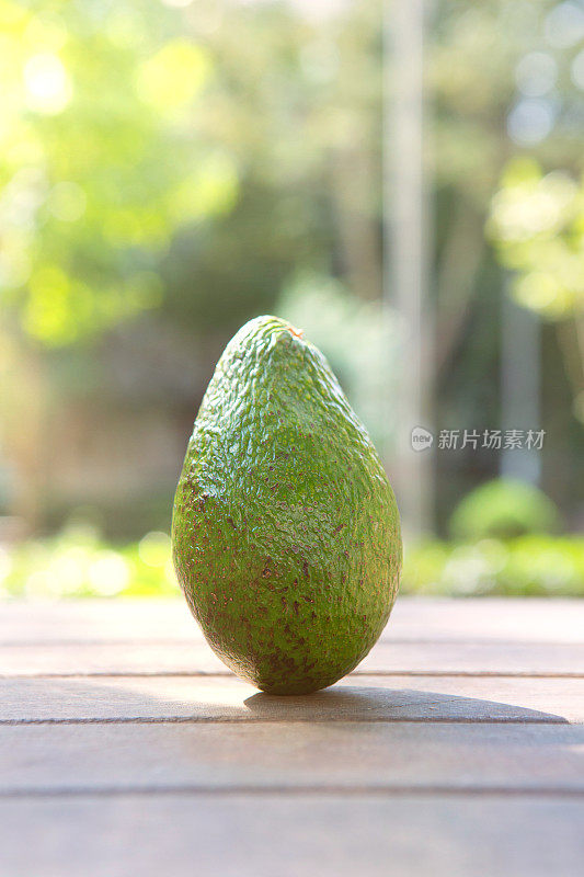 公园里的木桌上放牛油果。水果和蔬菜概念。