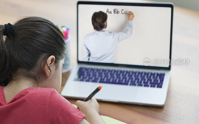 小女孩用笔记本电脑在网上上课