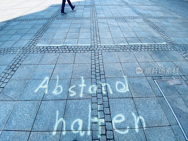 市场广场上的保持距离文字，德语:保持距离