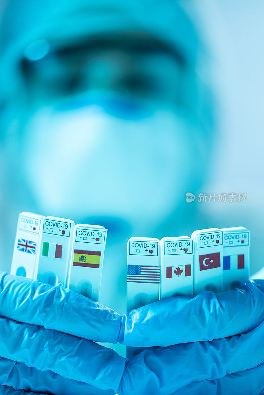 2019冠状病毒病医学检测包，上面有法国、英国、加拿大、西班牙、美国、土耳其和意大利国旗，戴着手术手套的人手