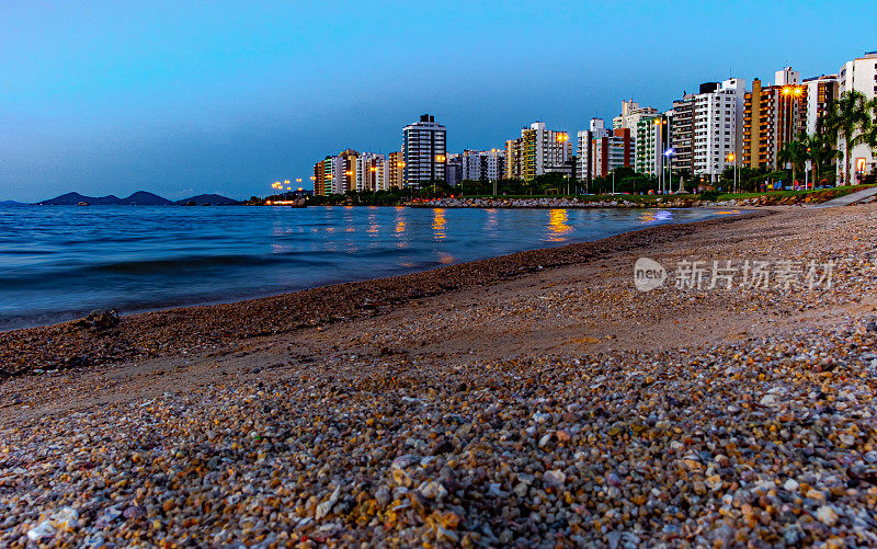 在Florianópolis的贝拉马尔大道的日落景观，与建筑反射在海上照明。