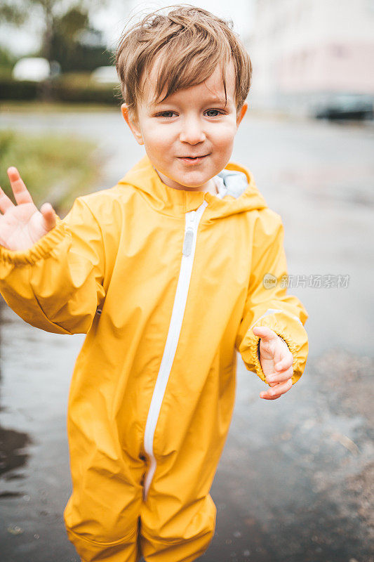小男孩在雨中玩耍，跳进水里画画