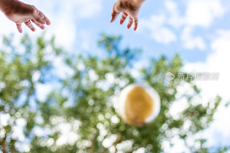 人的双手在户外伸向天空一个大橡皮球