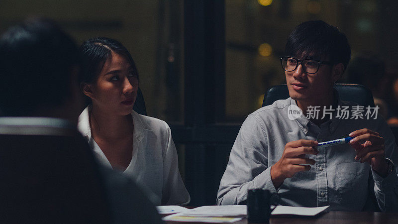 亚洲商人和商业女性会议头脑风暴的想法，新的文书项目同事一起工作，规划成功的策略，享受团队在小型现代夜间办公室。