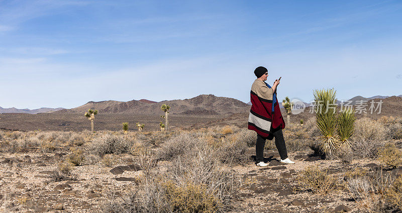 一个成熟的女人，一个游客，探索约书亚树生长在加利福尼亚的沙漠。