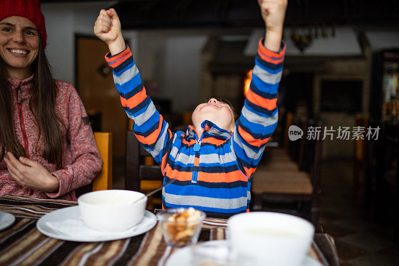 一个快乐的男孩，他的手臂在空中，他的手在拳头