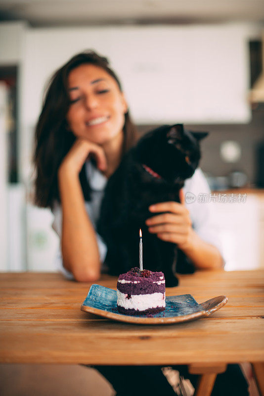 可爱的女人和她的黑猫庆祝她的生日