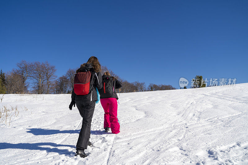 快乐的女人在雪地里奔跑和玩耍