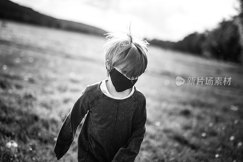 8岁男孩在草地上奔跑，戴着防护面具，黑白相间