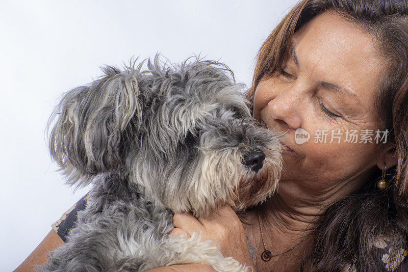 一位女士抱着她的雪纳瑞犬