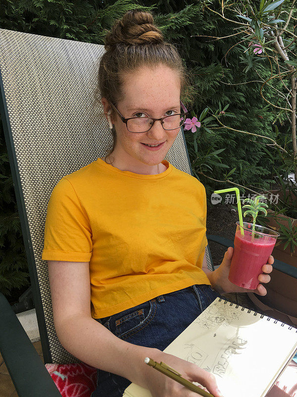 十几岁的女孩在花园里啜饮异国果汁，同时画画和放松