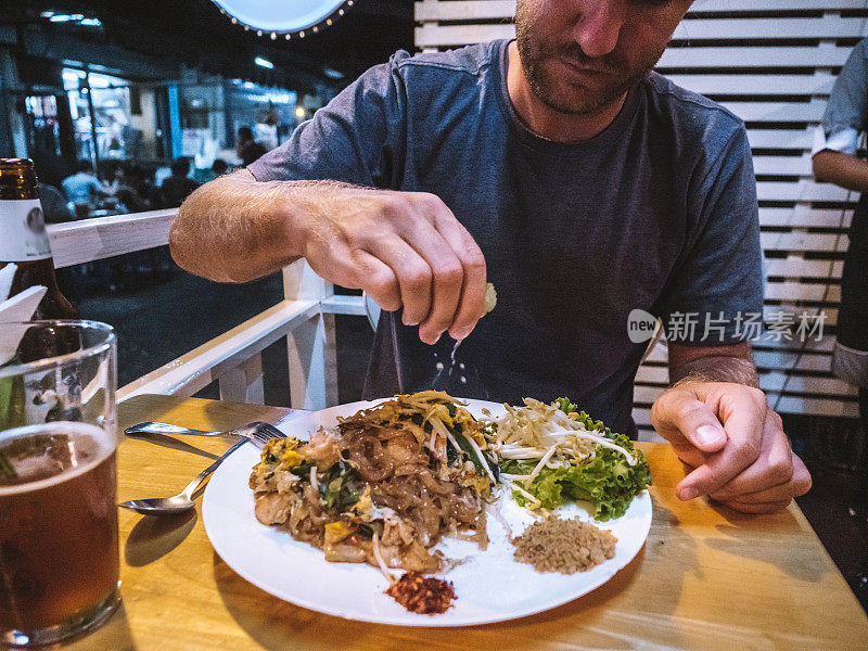 男子在当地餐馆吃泰式炒河粉