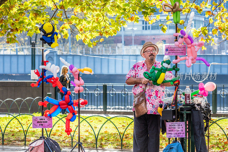 一个街头表演者正在制作和出售气球动物