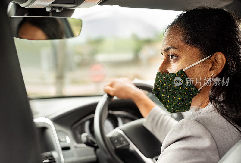 女商人戴着面具开车去上班