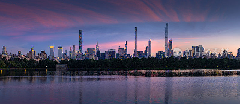 纽约市的天际线。曼哈顿中城的摩天大楼(亿万富翁排)从中央公园水库黄昏
