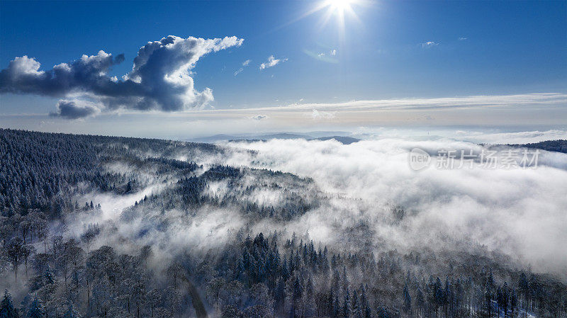 在晴朗而寒冷的冬日鸟瞰陶努斯山脉。雾和云在森林的上空
